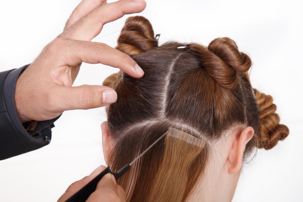 Woman removing hair extensions at home using proper techniques.