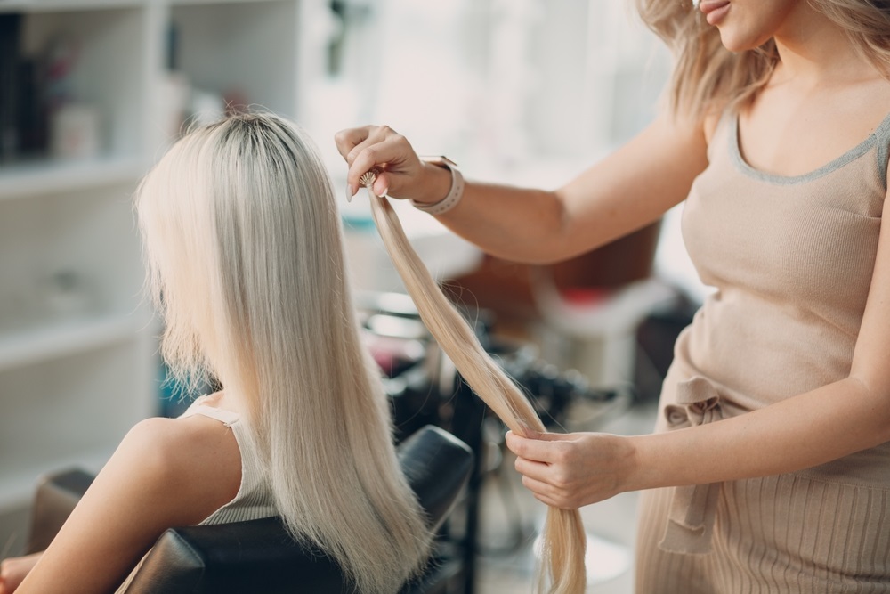 Woman removing hair extensions at home using proper techniques.